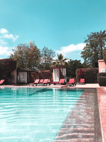 Piscine extérieure traditionnelle sur mesure avec finitions en pierre, créant une oasis de détente